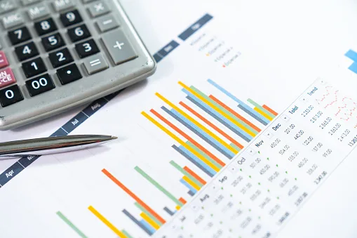 Graph with magnifying glass,Financial analysis, auditing or accounting ,calculators and dollar banknotes